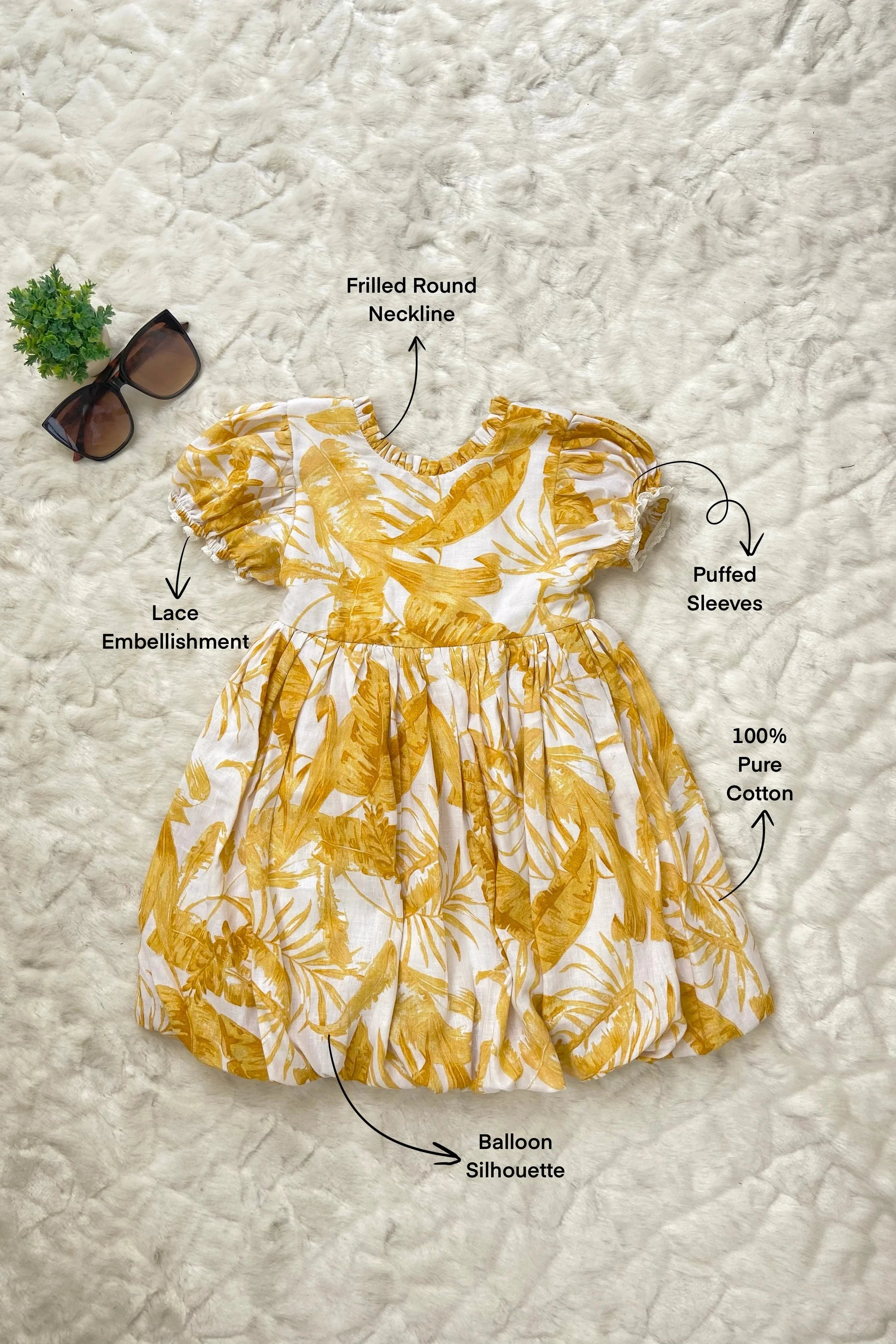 Flat image of yellow floral printed balloon dress for girls, made of cotton.